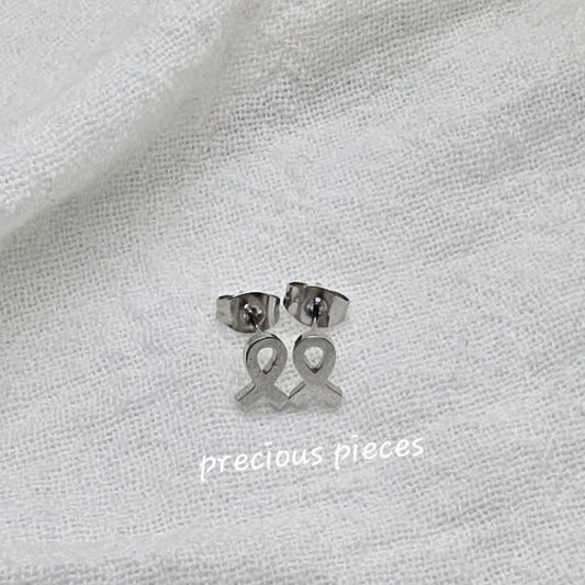 Silver earrings on a white fabric background with 'precious pieces' text.
